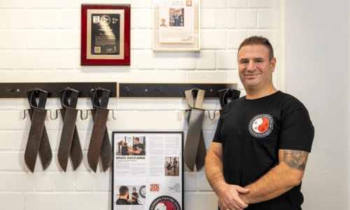 Sifu Enzo Zaccaria vor Auszeichnungen und Ving-Tsun-Trainingswaffen